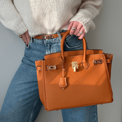 Marcellin – Struktureret håndtaske med elegant låsedetaljer og rummeligt interiør til daglig brug